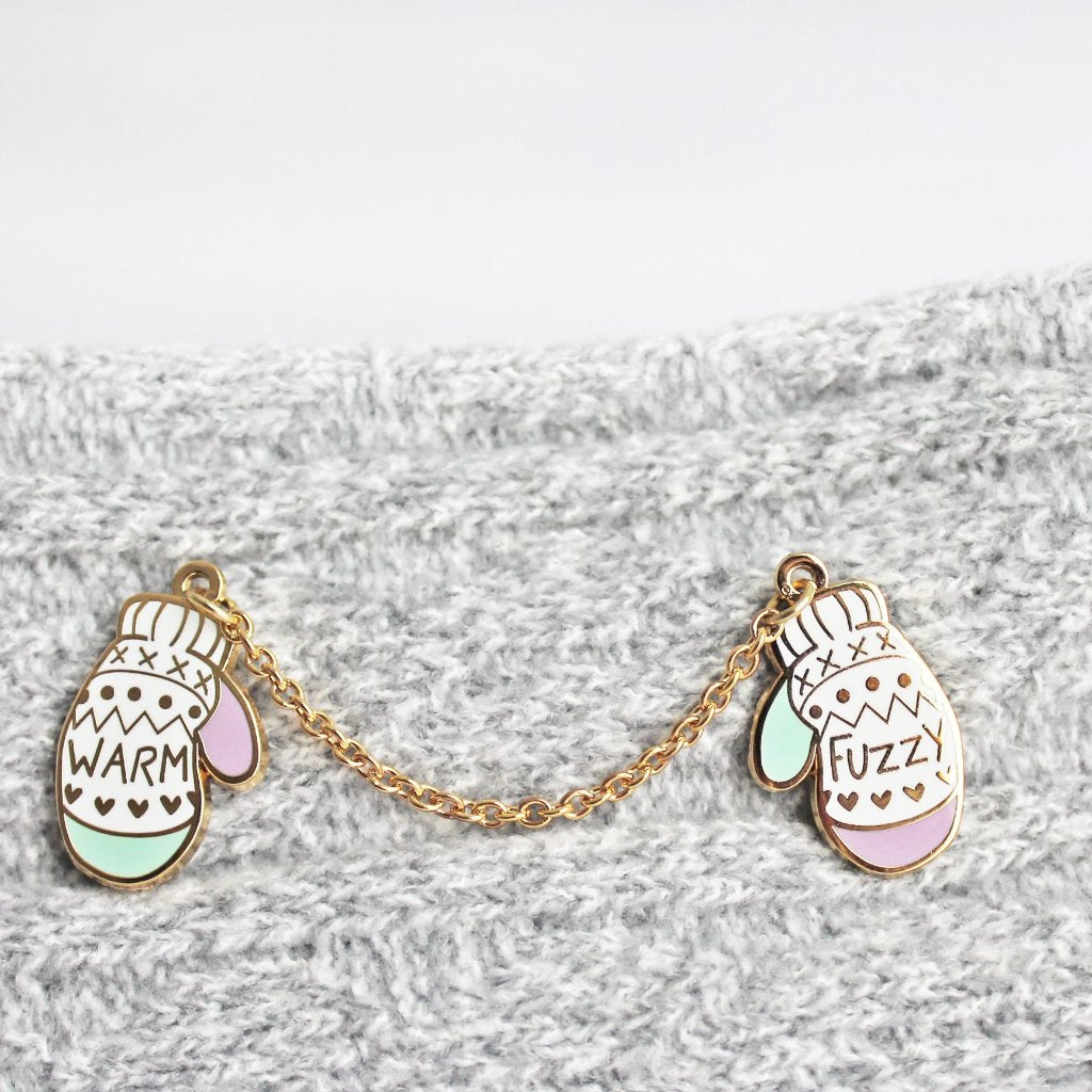 'Warm & Fuzzy' Mittens pin perfect for knitters and winter lovers. Unique enamel pin design, of two mittens attached by a chain.
