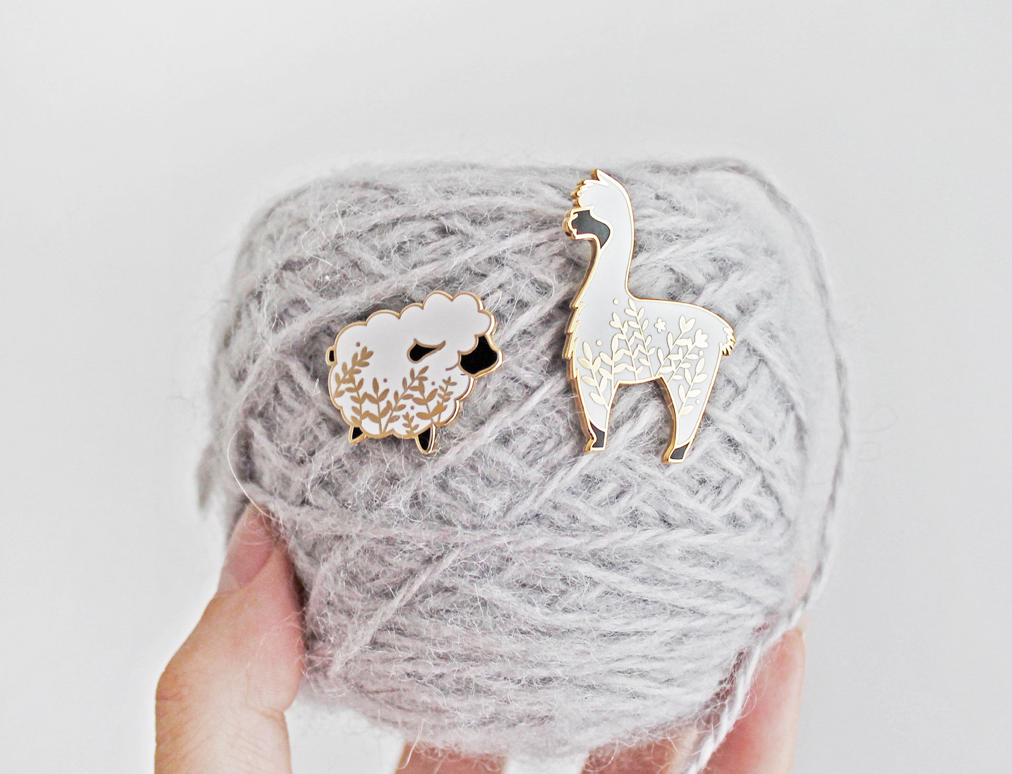 Cute alpaca enamel pin with a little floral whimsy. A beautiful pin made for animal lovers, fiber enthusiasts, knitters and crocheters.