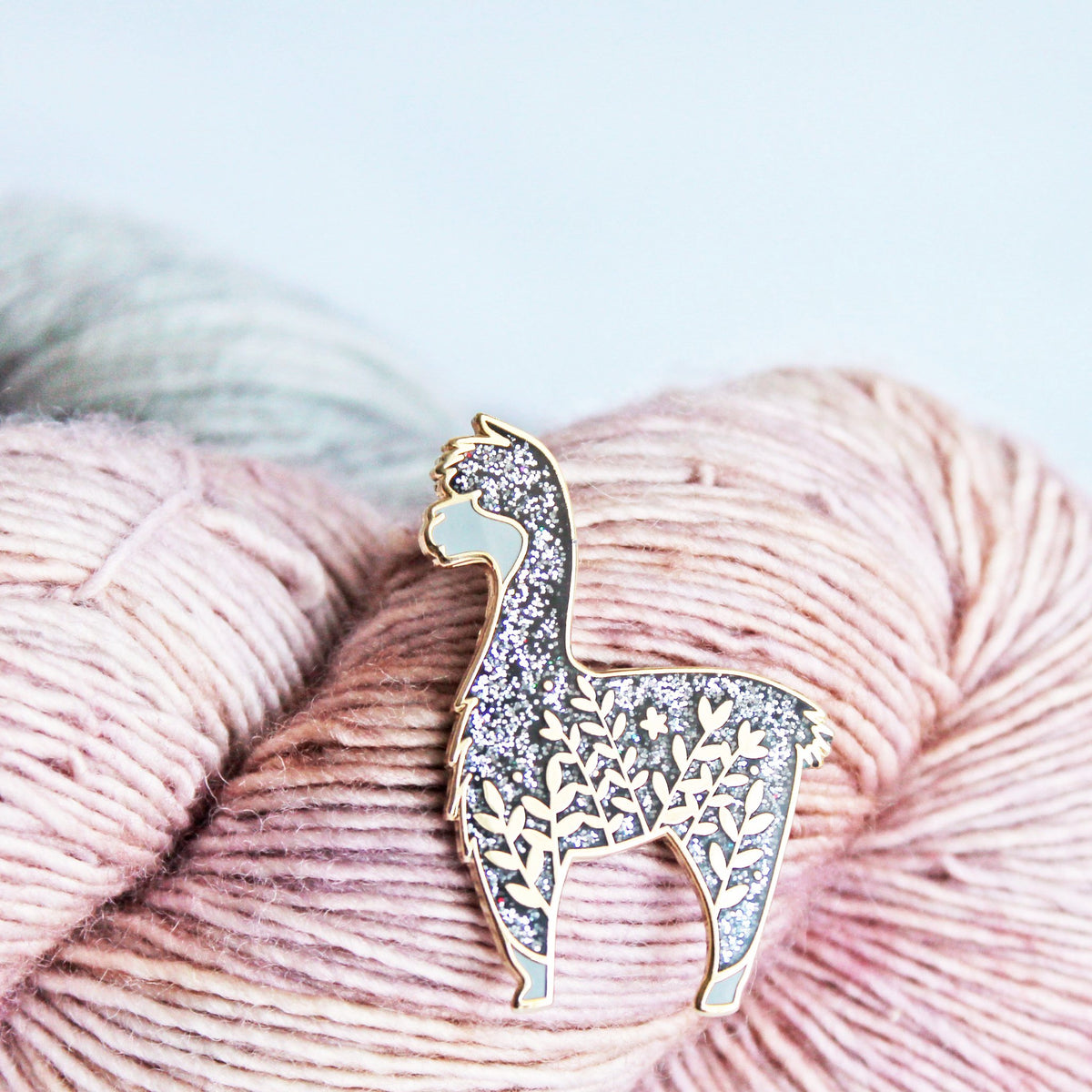 Cute alpaca enamel pin with a little floral whimsy. A beautiful pin made for animal lovers, fiber enthusiasts, knitters and crocheters.