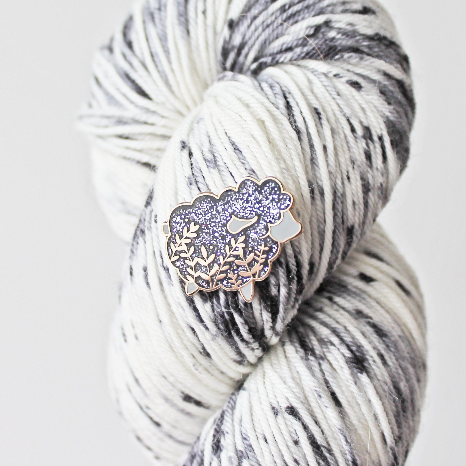 Cute sheep enamel pin with a little floral whimsy and glitter. A beautiful pin made for animal lovers, fiber enthusiasts, knitters and crocheters.