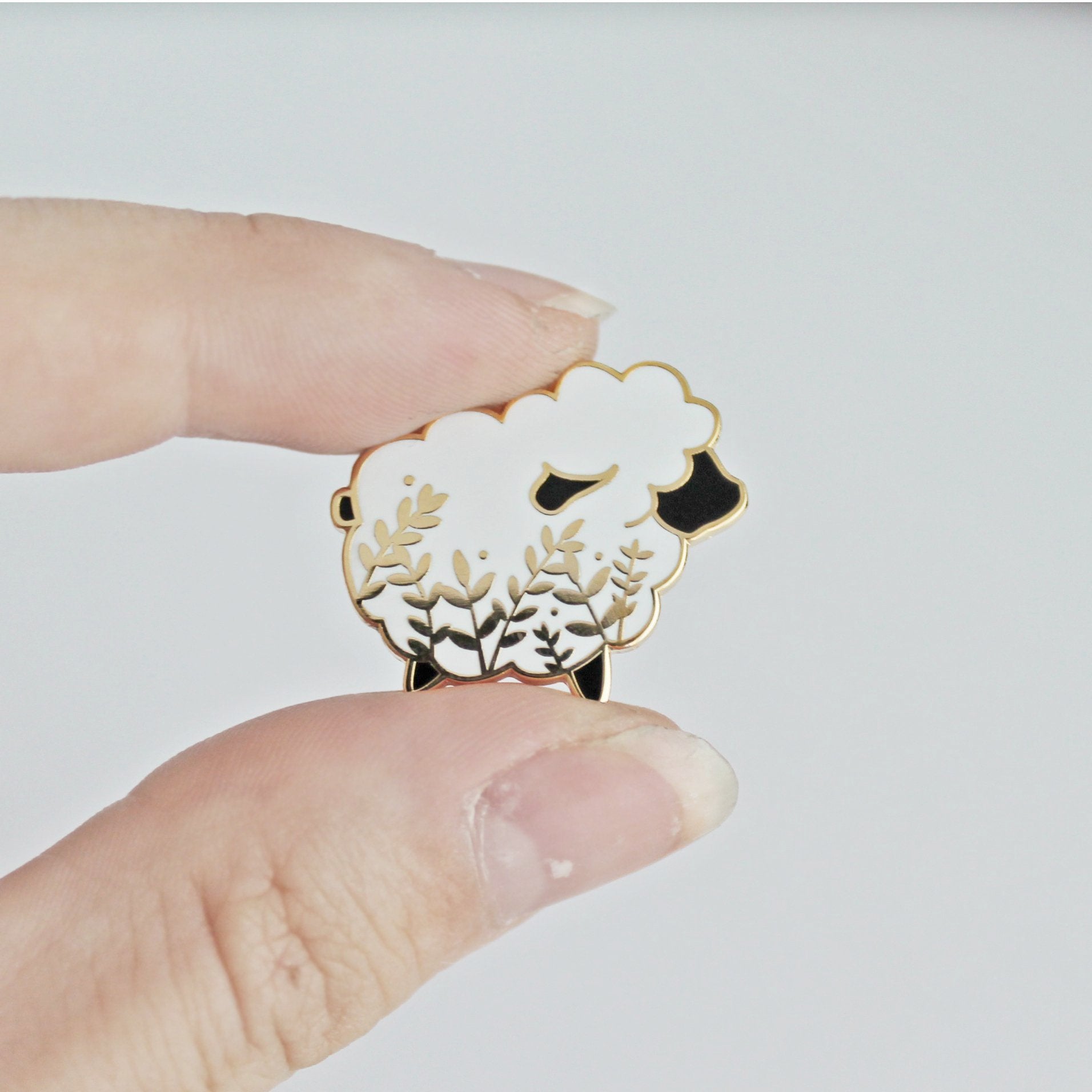 Cute sheep enamel pin with a little floral whimsy. A beautiful pin made for animal lovers, fiber enthusiasts, knitters and crocheters.